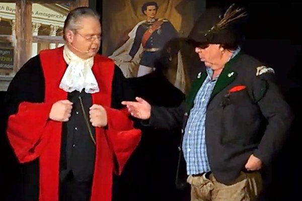Der Richter und ein Zeuge in Tracht diskutieren